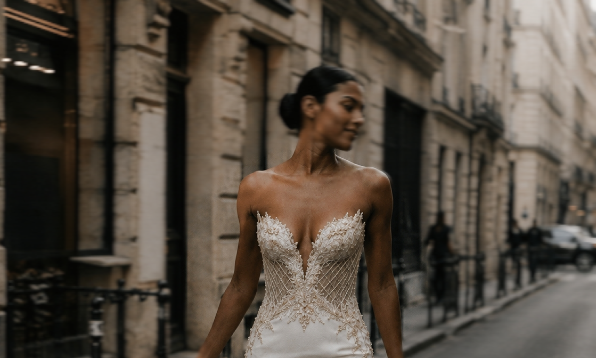 Nila porte la robe de mariée Couture Phoenix Rise dans une rue parisienne. Création atelier broderie Haute Couture au bustier brodé , et bas de la robe en crêpe de soie